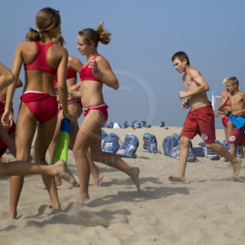 Young life guards running on the beach