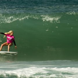 Laura Enever surfs into the tube of an overhead wave