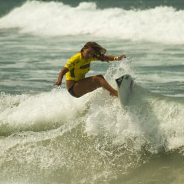 Pro Surfer Melanie Giunta riding the lip of a small wave