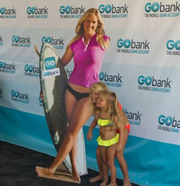 Young surfer girls standing next to a Bethany Hamilton life size poster