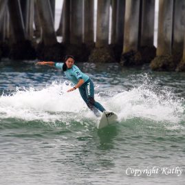 Malia Manuel surfing next to the Huntington Beach pier