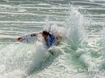 Carissa Moore grabs her board's rail on a wave