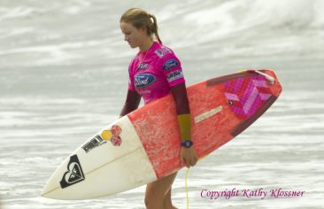 Bianca Buitendag walks to the beach with her surfboard