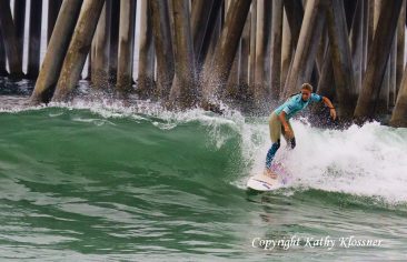 Paige Hareb surfing a wave near Huntington Beach Pier