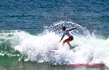 Nikki Van Dijk sprays water off a wave