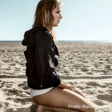 Brazilian Maya Gabeira sitting on the sand.