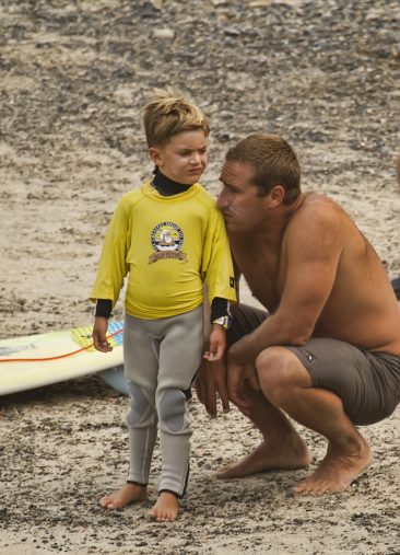 A father and son getting ready for the 7 & under surf contest